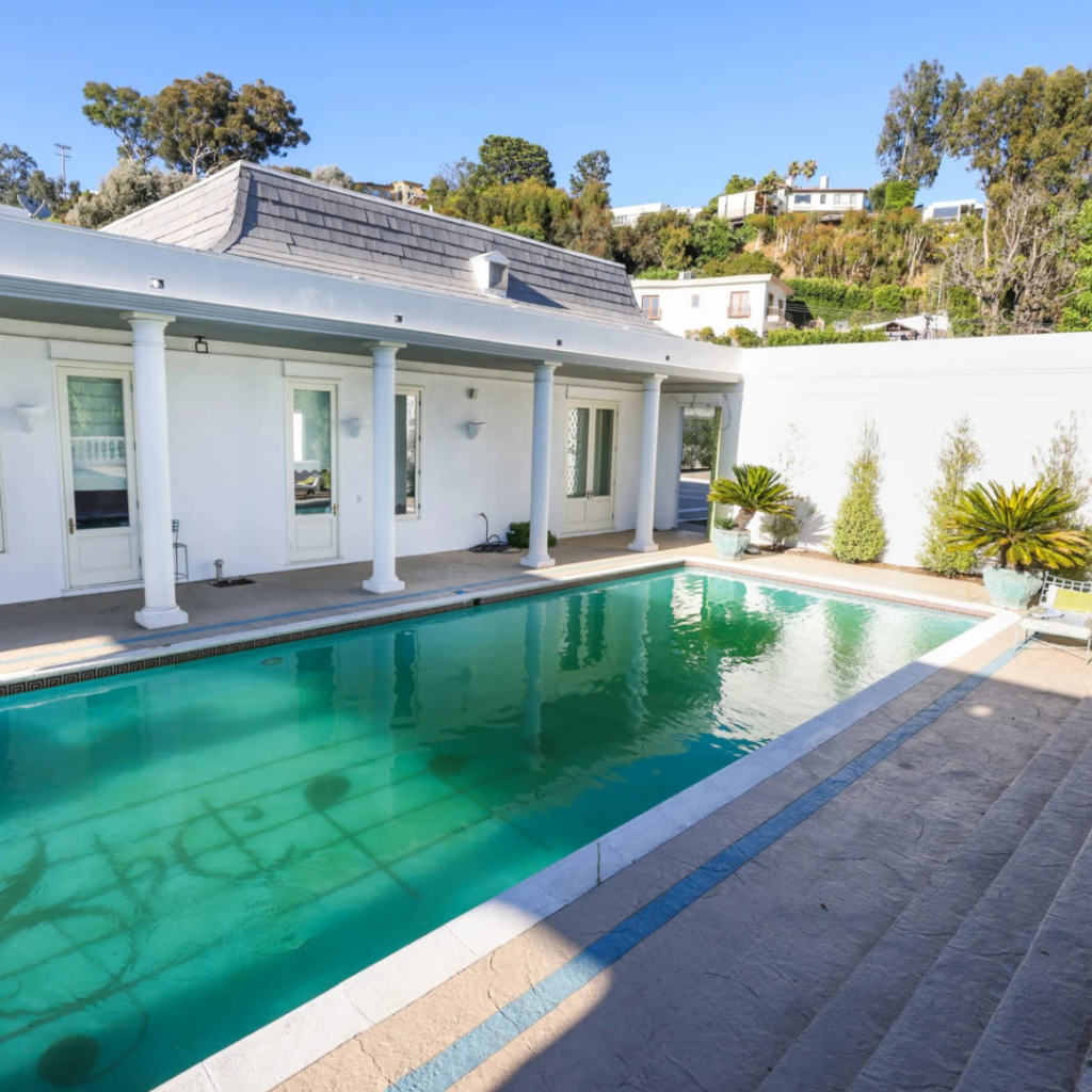Elegant pool surrounded by classic white columns, ideal for cocktail hour or evening ambiance at luxury events