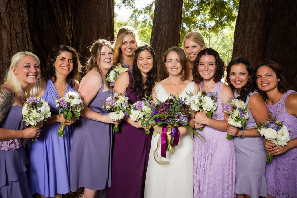 Luxury wedding bridal party with bridesmaids in elegant gowns surrounding the bride, capturing timeless style and joyful celebration.