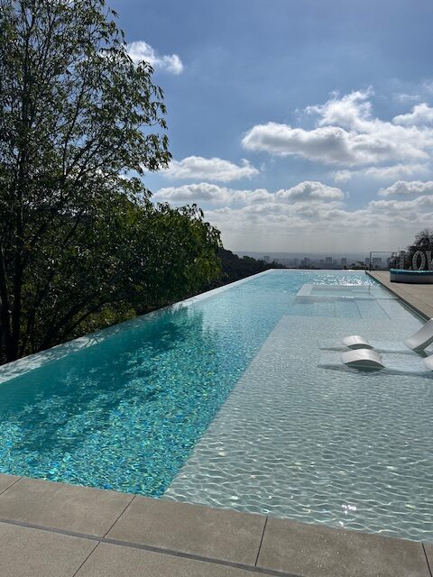 Sunlight rippling across the pool at a modern Beverly Hills estate, quiet and serene.