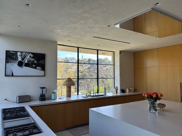 Modern kitchen at a luxury Beverly Hills estate, featuring natural light, warm wood tones, and minimalist design.