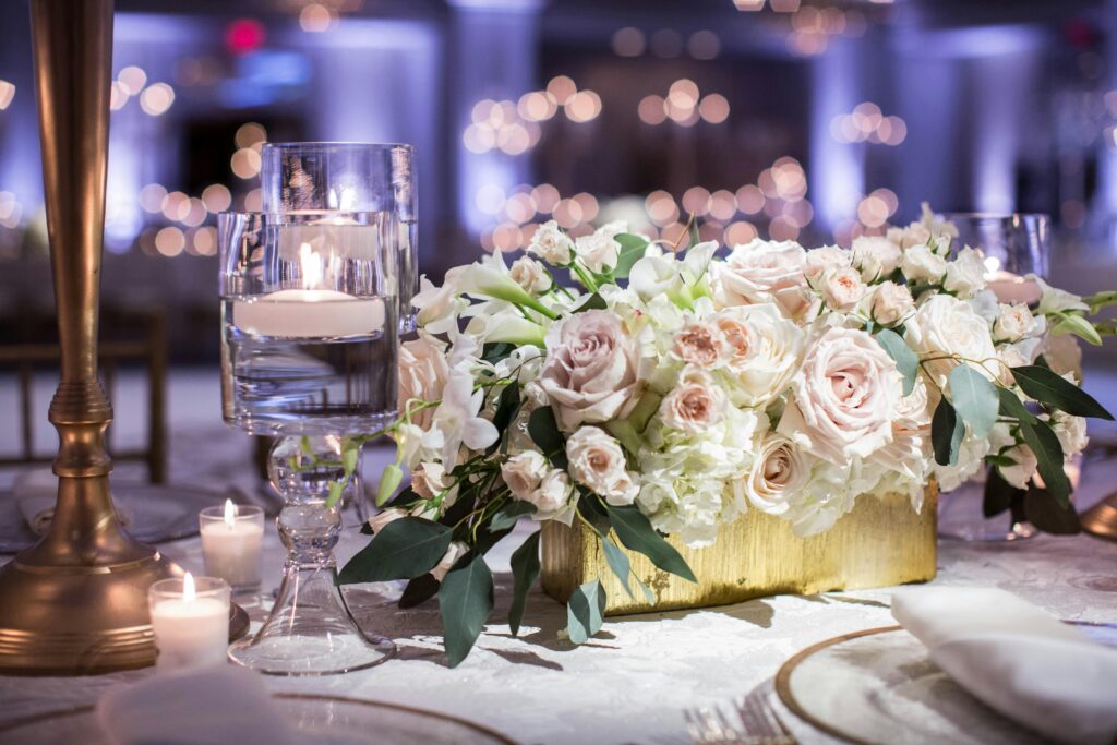 Luxury wedding design inspired by emotion — candlelit tablescape with ivory florals and gold accents.