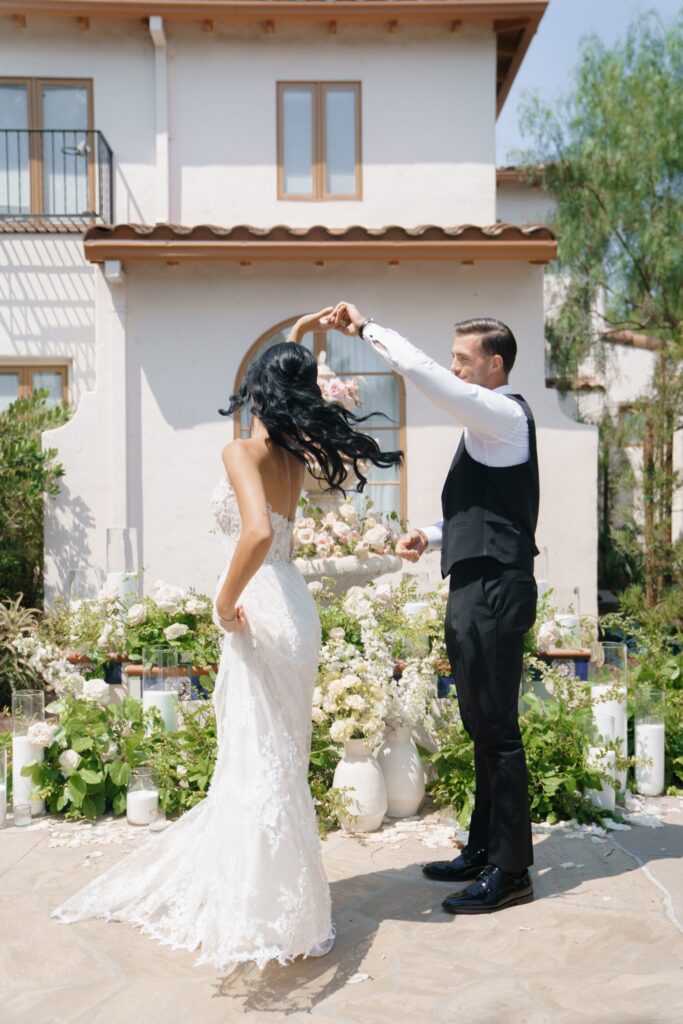 Luxury outdoor wedding ceremony setup with bride and groom walking under floral arch in Los Angeles venue”
