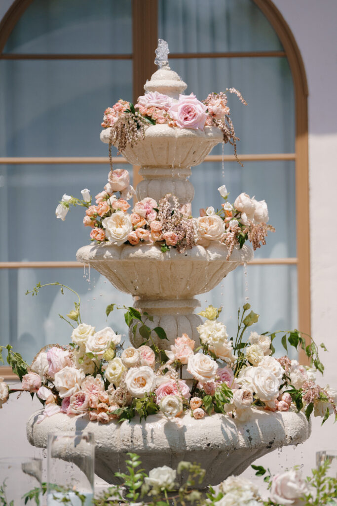 Architectural estate fountain adorned with refined florals at a luxury Los Angeles wedding