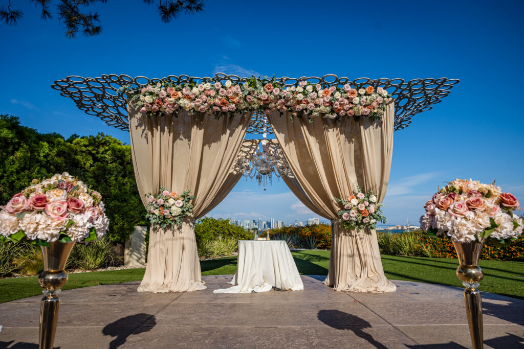 elegant outdoor wedding ceremony at Tom Ham’s Lighthouse in San Diego, California with white floral arch and structured aisle, planned by Marshecka Weddings