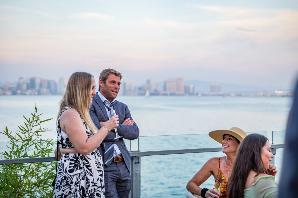 Guests enjoying meaningful conversation during a waterfront wedding reception experience in San Diego designed with hospitality and atmosphere in mind by Marshecka Weddings.